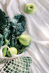 White net shopping bag with green fruit and veg