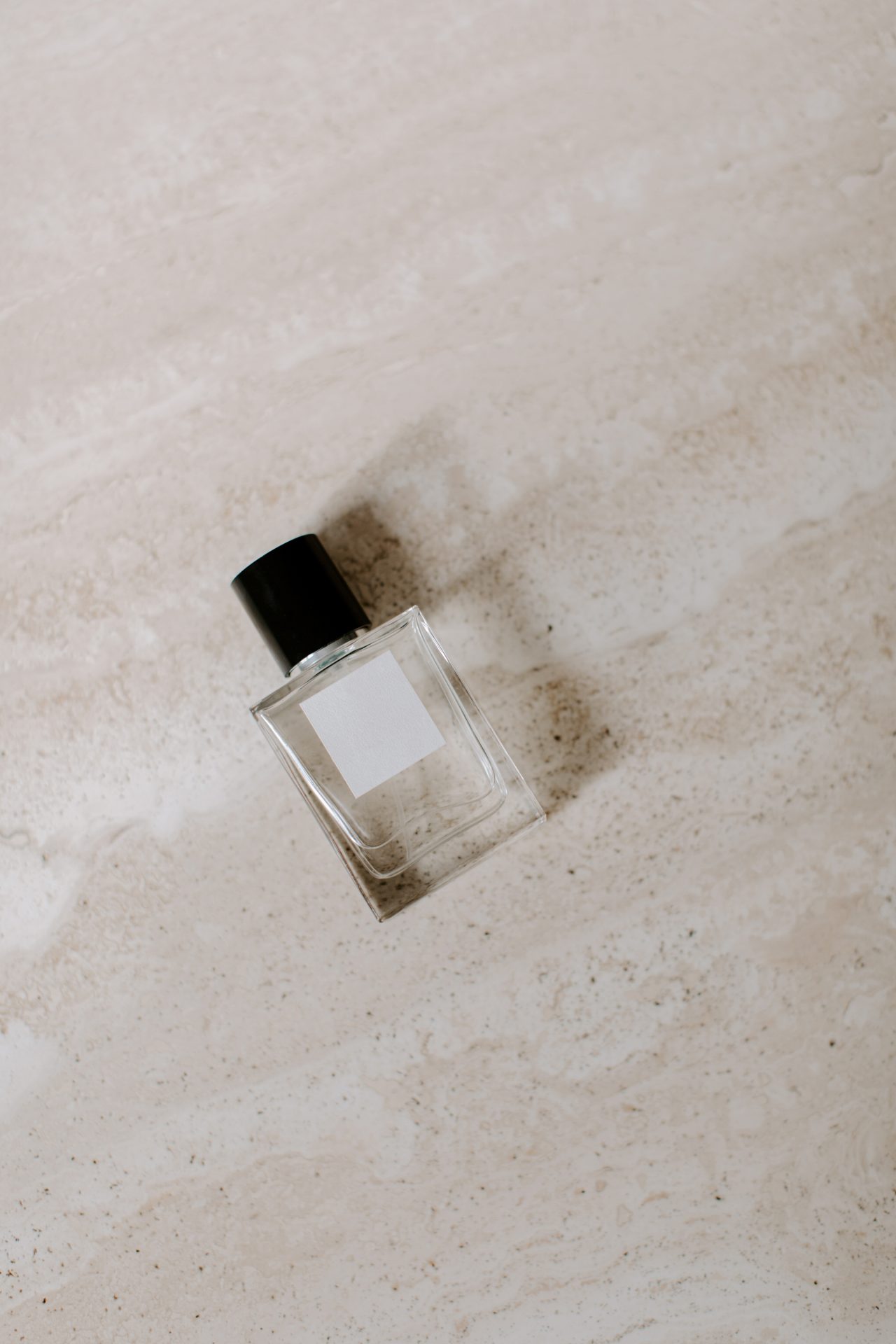 Nondescript bottle of perfume with natural background