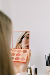 Blonde woman applying makeup