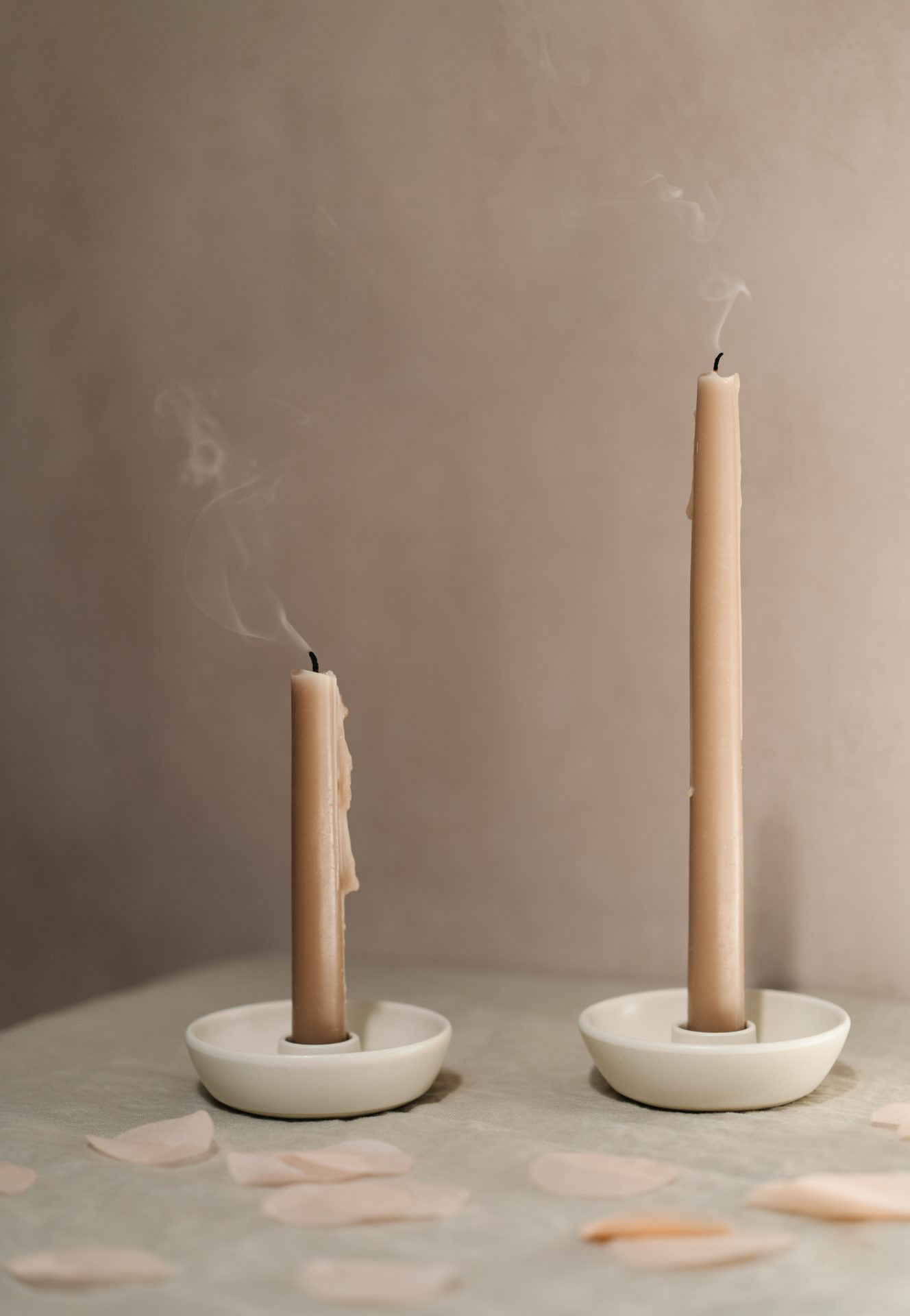 two natural candle sticks blown out with smoke flowing from them