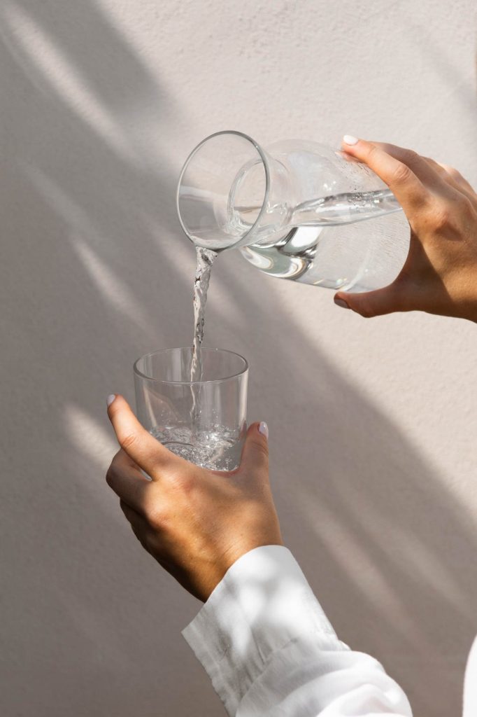 Hands pouring water into a glass