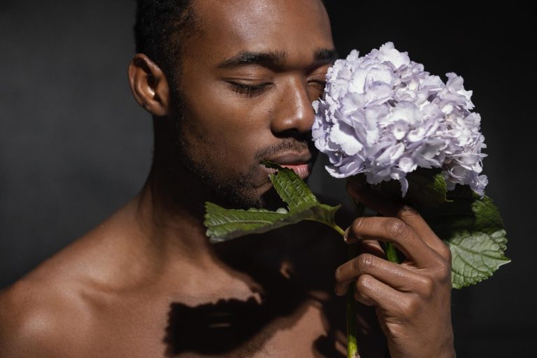 Young black man holding a lilac hydrangea
