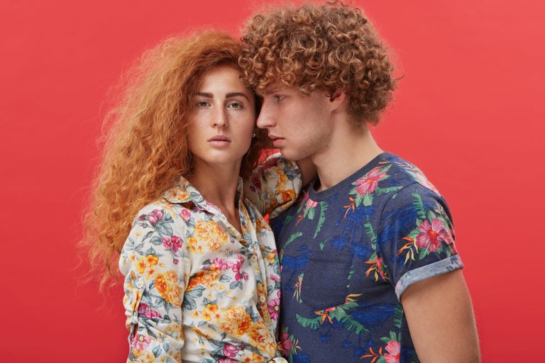 Man and woman with curly ginger hair and colourful clothes